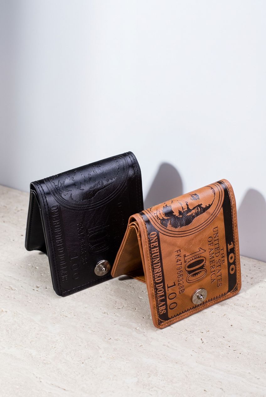 Duas carteiras masculinas bifold de couro, uma marrom e outra preta, ambas com design de nota de 100 dólares em relevo e fecho de botão, abertas em um ângulo, exibindo o interior
