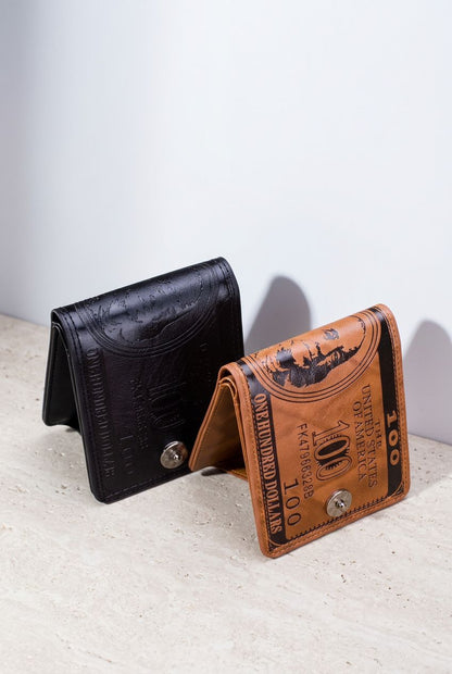 Duas carteiras masculinas bifold de couro, uma marrom e outra preta, ambas com design de nota de 100 dólares em relevo e fecho de botão, abertas em um ângulo, exibindo o interior